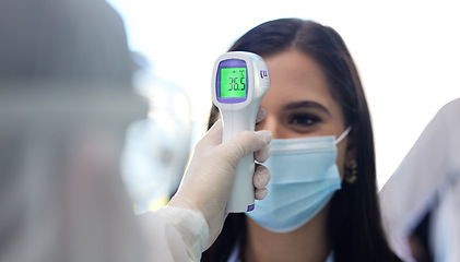 Image showing Ensuring everyone is safe. a group of businesspeople standing in a line to get their temperatures read.