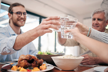 Image showing Cheers to family and togetherness through the years. a family toasting with drinks while having a meal together at home.