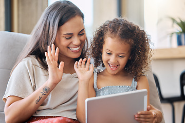 Image showing Hispanic mother and little daughter waving with a hand gesture while using a digital tablet for a video call at home. Little girl and woman greeting someone on a call while smiling
