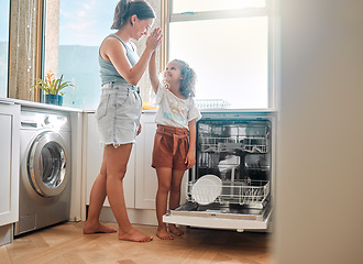 Image showing Little girl helping her mother with household chores at home. Happy mom and daughter giving high five while unloading the dishwasher together. Kid learning to be responsible by doing tasks