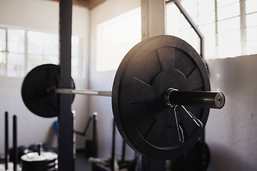 Image showing Heavy barbell weights and bar arranged in empty gym with nobody during day. Metal weightlifting equipment organised in a health club and sports centre with no one inside. Healthy exercise routine