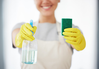 Image showing One unrecognizable woman holding a cleaning product and sponge while cleaning her apartment. An unknown domestic cleaner wearing latex cleaning gloves