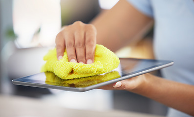 Image showing An unrecognizable woman cleaning her digital tablet in her apartment. One unknown woman using a rag to remove dust from her device