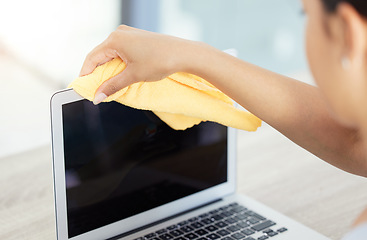 Image showing An unrecognizable woman cleaning her laptop in her apartment. One unknown woman using a rag to remove dust from her laptop keyboard