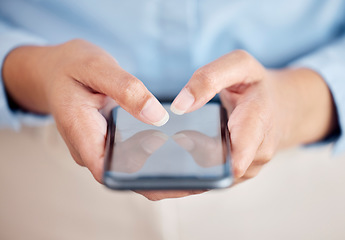 Image showing Unrecognizable business woman holding and working on a phone in their hand while standing inside a office at work. Unrecognizable female typing a message and using social media showing their screen