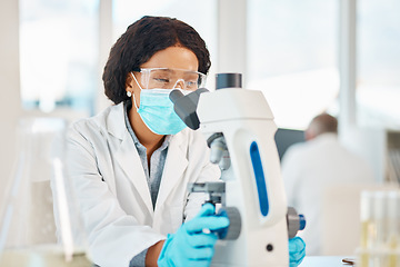 Image showing I hope my theory is right. a young scientist using a microscope in a lab.