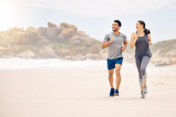 Image showing A change of scene was needed and appreciated. a sporty young couple running together on the beach.