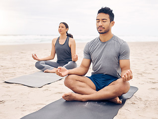 Image showing Challenging mind and body in equal measure. a young couple meditating while practising yoga together on the beach.