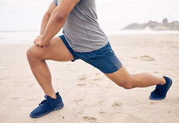 Image showing Get your legs ready for it. Closeup shot of an unrecognisable man stretching his legs while exercising on the beach.