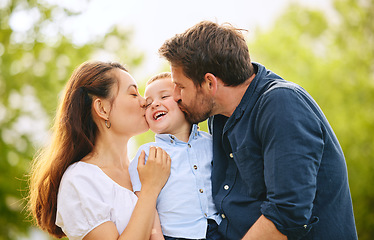 Image showing A kiss for our cutie. a young family spending time together at the park.