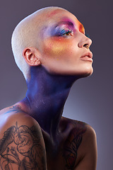 Image showing Shes a colourful soul. Studio shot of a young woman posing with multi-coloured paint on her face.