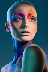 Image showing Colour is a wonderful thing. Studio shot of a young woman posing with multi-coloured paint on her face.