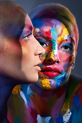 Image showing Everyone needs a little colour in their life. Studio shot of two young women posing with multi-coloured paint on her face.