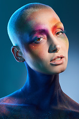 Image showing Create your own beautiful world. Studio shot of a young woman posing with multi-coloured paint on her face.