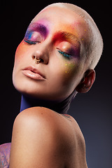 Image showing Live life colourfully. Studio shot of a young woman posing with multi-coloured paint on her face.