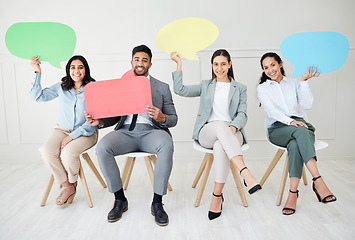 Image showing Say it again for the people in the back. Portrait of a group of businesspeople holding speech bubbles while sitting in line against a grey background.