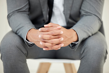 Image showing He cant afford to make the wrong decision. Closeup shot of an unrecognizables hands while sitting nervously in the studio.