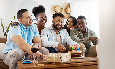 Image showing Its time to blow out your candles. a young man celebrating his birthday with friends at home.