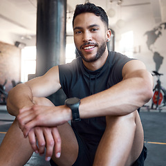 Image showing Its important to take breaks in between sets. Portrait of a sporty young man taking a break while exercising in a gym.