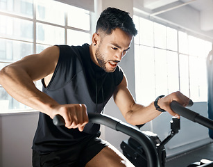 Image showing The more you beast, the more you gain. a sporty young man working out on an exercise bike in a gym.