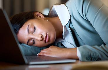 Image showing Some days are longer than others. an attractive young businesswoman sleeping on her desk while working late at the company offices.