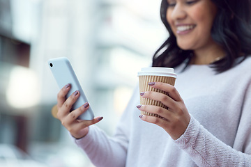 Image showing Coffee and important contacts, what more does an entrepreneur need. a young businesswoman having coffee and using a smartphone against an urban background.