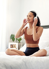 Image showing Inhale goodness, exhale negativity. a young woman listening to music while sitting on her bed at home.