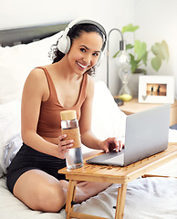 Image showing Take time to be present. a young woman using a laptop while sitting on her bed at home.