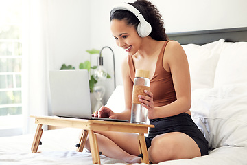 Image showing Ive found a new show to watch. a young woman using a laptop while sitting on her bed at home.