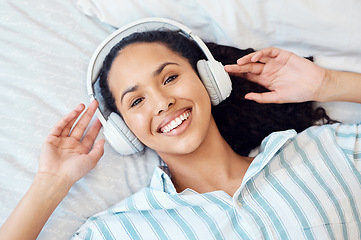 Image showing Allowing the music to take me away. a young woman listening to music while sitting on her bed at home.