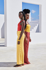 Image showing Colour your life. Full length shot of two attractive young women posing on a rooftop outdoors.