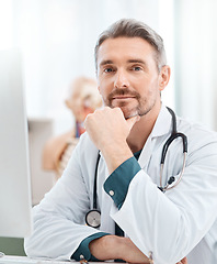 Image showing There are always new developments happening in the medical world. Portrait of a mature doctor working on a computer in a medical office.