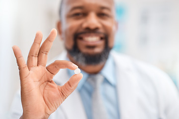 Image showing I highly recommend this brand. Closeup shot of a doctor holding a round white tablet.