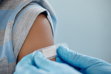 Image showing Vaccinated to stay protected from certain infectious diseases. Closeup shot of an unrecognisable doctor applying a plaster to a little boys arm after an injection.