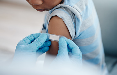 Image showing Vaccines are an important means of keeping your child healthy. Closeup shot of an unrecognisable doctor applying a plaster to a little boys arm after an injection.