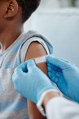 Image showing He sat still and was so brave for his jab. Closeup shot of an unrecognisable doctor applying a plaster to a little boys arm after an injection.