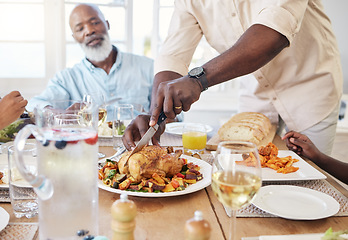 Image showing He always gets the best cut. a unrecognizable man cutting the chicken for his familys lunch at home.