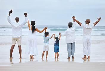 Image showing Jump on three. Rearview shot of a family spending the day at the beach together.