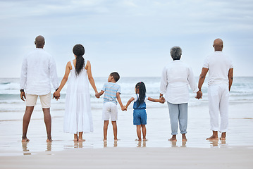 Image showing Wet your feet with us. Rearview shot of a family spending the day at the beach together.