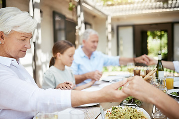 Image showing Food brings us together, love keeps us together. a family saying grace while sitting together at the dining table.