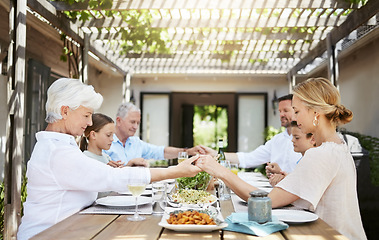 Image showing Saying grace before a meal is a long-held tradition. a family saying grace while sitting together at the dining table.