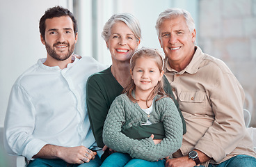 Image showing Cute little girl sitting on the couch together with family. Happy child sitting with her father and grandparents at home. Caucasian family smiling while relaxing together during a visit