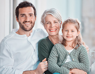 Image showing Portrait of three family members looking and smiling at the camera. Adorable little girl bonding with her grandmother and father at home