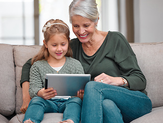 Image showing I can see why you love this show. a grandmother and granddaughter bonding on the sofa while using a digital tablet.