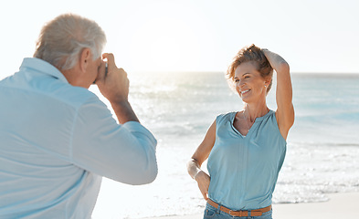 Image showing My eyes are on the best view here. a man taking a picture of his wife while at the beach.