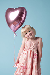 Image showing Everyone deserves balloons. an adorable little girl holding a heart balloon against a studio background.