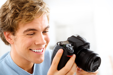 Image showing Looking for that perfect shot. a young man using his digital camera at home.