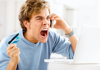 Image showing Double deductions ruining his day. a young man making an angry phone call while making online payments.