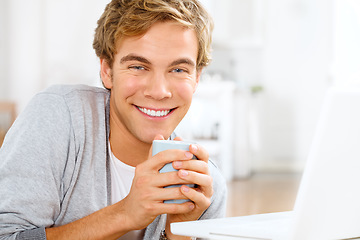 Image showing A lovely cup to start the day. a young man drinking coffee while working on his laptop.