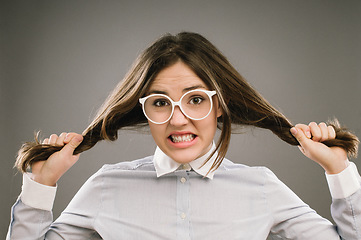 Image showing Ready to rip my hair out. a young woman pulling her hair against a studio background.